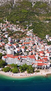 Croatia, aerial view of coastal town with white buildings, red roofs, and beach