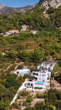 Croatia, aerial view of modern luxury villas with swimming pools nestled in lush green hills and mountains