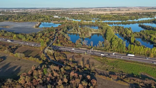 vue a&eacute;rienne panoramique des &eacute;tangs et de l'autoroute A31 pr&egrave;s de Saint R&eacute;my et La Maxe entre Thionville et Metz. La v&eacute;g&eacute;tation aux couleurs d'automne avec un ciel bleu sans nuage. Lorraine, France 