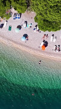 Croatia, aerial footage of a beautiful beach with crystal clear water and sunbeds