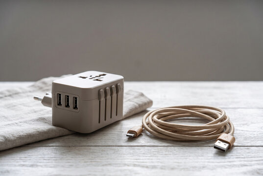 Travel adapter and braided charging cable on a neutral surface