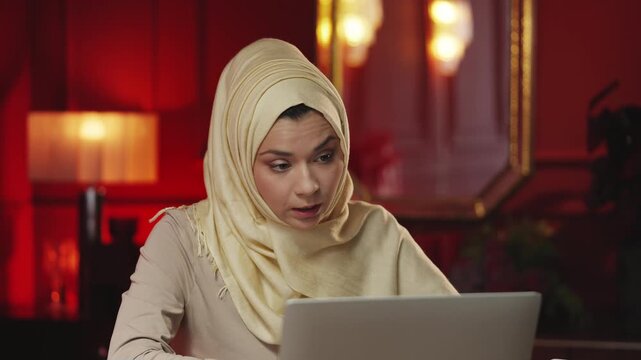 Middle Eastern female tutor conducting online video lecture on laptop at home