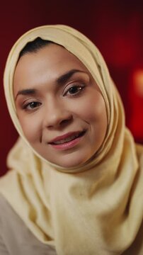 POV of young Arab woman in hijab having video call on phone while at home