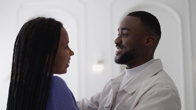 Happy African American couple embracing and smiling at home, loving relationship