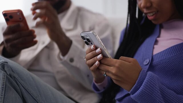 African American woman and boyfriend scroll social media on their phones