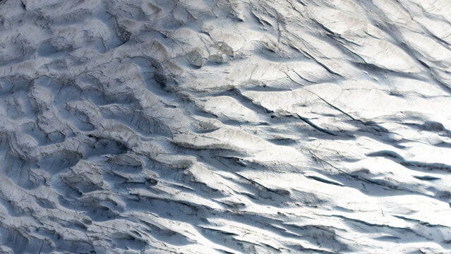 Aerial view of the intricate patterns of the glaciers showing deep crevasses and textured ice formations in Kirkjubaejarklaustur, Skaftarhreppur, Iceland.
