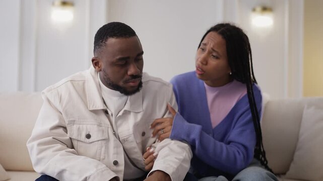 Kind African American woman comforts and hugs her desperate boyfriend
