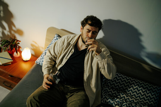 Overwhelmed male turns to strong alcohol to cope with intense pressure. Acute mental breakdown