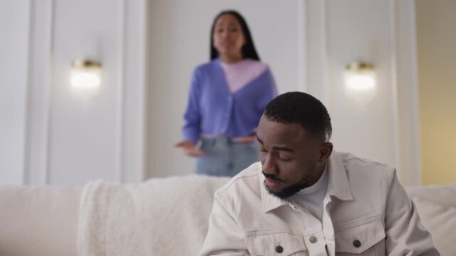 Young African American man listens to annoyed girlfriend during heated argument