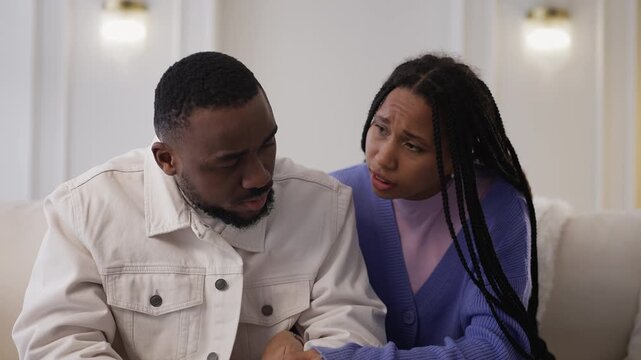 Caring Black woman consoles and embraces upset boyfriend, showing support