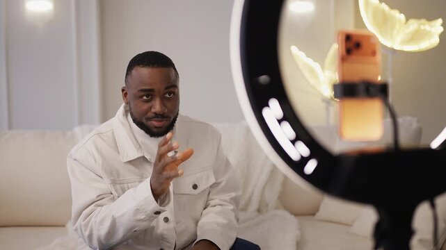 Young African American man records lifestyle blog on phone, livestreaming