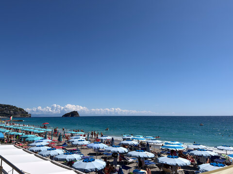 The beach clubs along the sandy shores of Spotorno in the height of summera time for holidays and fun. Ideal for tourism, vacations, and documentaries about Italian beaches