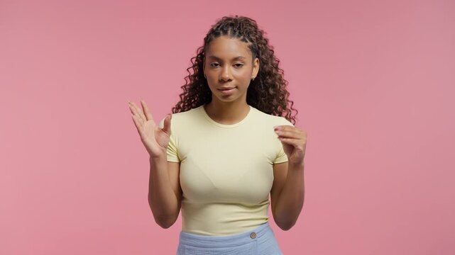 Annoyed teenage girl showing bla-bla gesture with hands on pink background. Empty promises, irony, blah concept. Lier