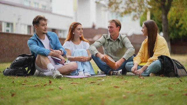 Group of university students talking on campus lawn