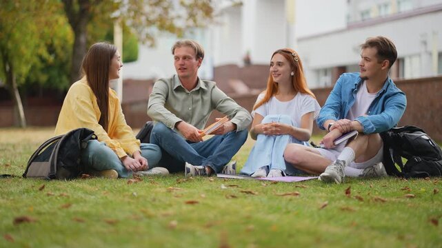 University students talking together on campus lawn