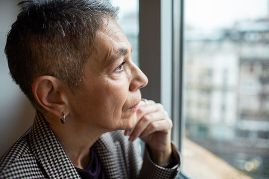 Senior woman gazing out the window thoughtfully
