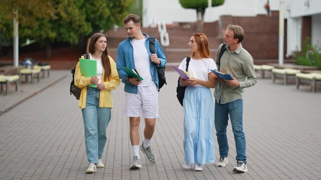 Group of university students walking and talking on campus