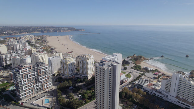 Aerial view of Praia da Rocha with high-rise buildings, sandy beach, and coastline in Faro District, Portugal.