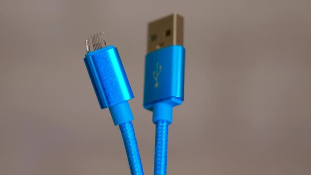 Broken blue usb data cable connector. Extreme close-up of a damaged and frayed blue micro usb connector next to a standard usb-a plug, showing the internal broken pins and wires making the charging