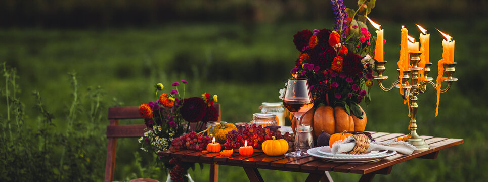 Banner. Fall table decoration with pumpkin composition. Family cozy thanksgiving dinner arrangement outdoors, in a garden, elegant wedding decor. Countryside style, rose wine, fruits, autumn mood