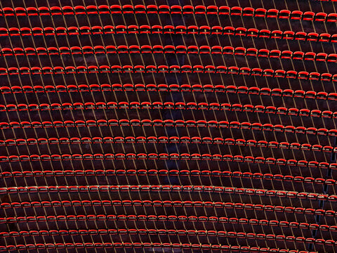 Aerial view of rows of empty red stadium seats at the LA Memorial Coliseum in Los Angeles, California, United States.