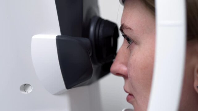 Patient receiving ophthalmological examination with corneal imaging equipment for diagnosis of eye conditions and vision problems.
