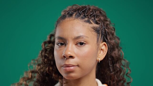 Serious teenage girl disapproving with no head sign, nods head disapprovingly. Denying, Rejecting, Disagree, Portrait of pretty young woman on green background