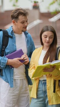 Two university students discussing homework outdoors on campus
