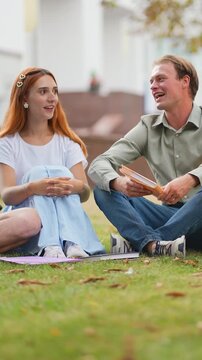 Young couple enjoying a relaxing conversation sitting on grass