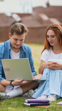 University students collaborating on laptop outdoors