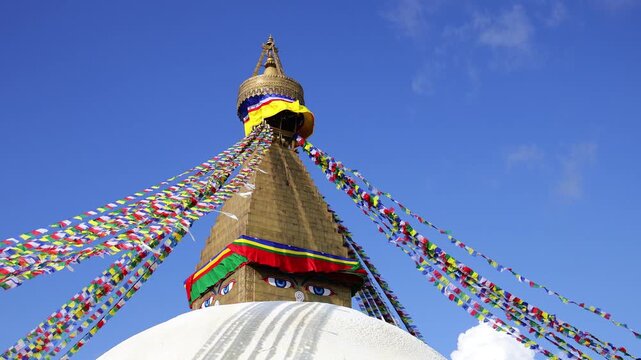 Sacred Buddhist stupa adorned with colorful prayer flags in Kathmandu, Nepal, surrounded by traditional religious architecture and a peaceful spiritual atmosphere