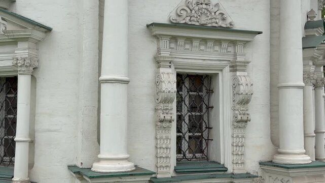 Close up shot of ancient Pyatnitskaya Chapel facade with carved white stone window frames and decorative columns in Sergiyev Posad. Historical russian orthodox architecture, Golden Ring heritage.