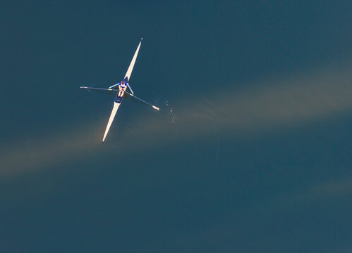 Aerial view of a single rower in a sculling boat on the calm waters of the Dead Vistula in Gdansk, Pomeranian Voivodeship, Poland.