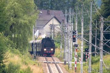 Historic TKt48 steam locomotive pulling a retro passenger train on the railway tracks near Chabowka, Poland © lumofoto