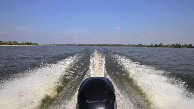 Boat wake trail from outboard motor on river
