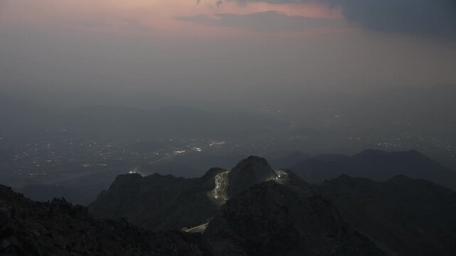 Taif, Saudi Arabia - Night illuminated winding mountain road in Al Hada, Taif with city lights and traffic, 4K footage video