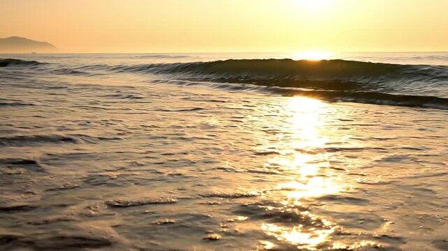 Golden sunset over the calm ocean waves at the beach