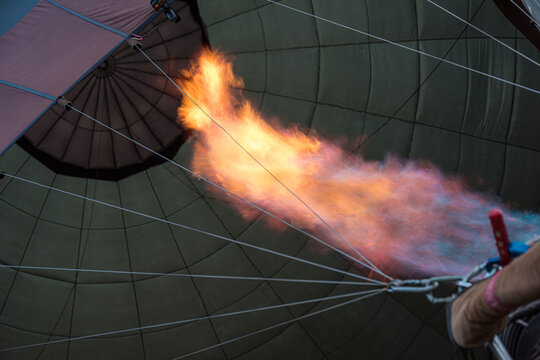 Hot air balloon burner producing a powerful flame, inflating the envelope for an adventurous journey