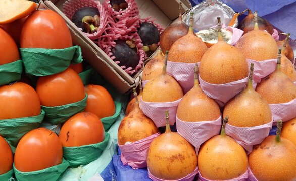 Persimmons and sweet granadillas on display at a fruit market