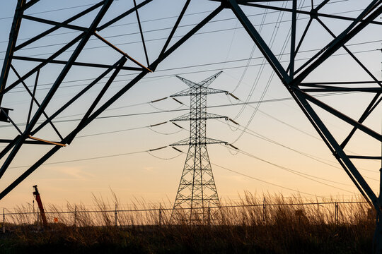 Energy grid infrastructure with high voltage pylons.
