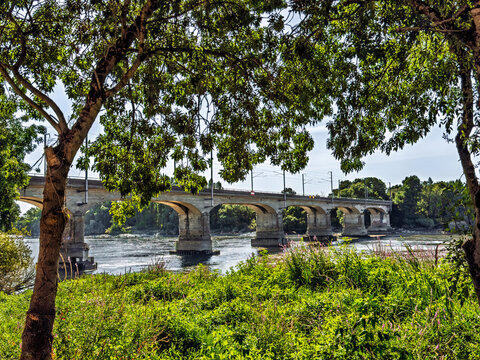 Nantes, France, Europe - August 10, 2026: Historic railway bridge over the Loire River southern arm, 
Arm de Pirmil, as seen from the Parc Naturel de Beaulieu