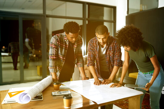 Architecture, night and people with blueprint in meeting for design, floorplan or building project. Creative team, engineering and workers with paperwork for planning, layout and renovation in office