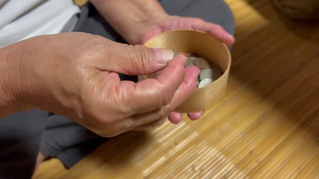 硬貨を手にのせる高齢者
