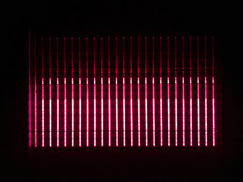 Aerial view of a greenhouse illuminated by vibrant red LED grow lights at night in the Netherlands.