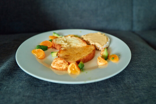 Toast and Hummus Rice Cake With Mandarin and Avocado on a Plate