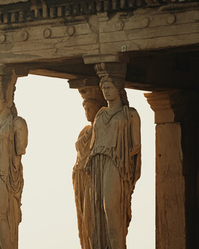 View of the Caryatids at the Erechtheion on the Acropolis, featuring ancient marble statues of draped female figures supporting the temple roof, Athens, Greece.
