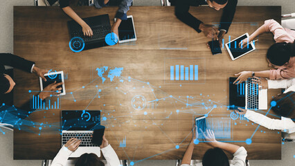Fototapeta na wymiar A vibrant and modern collaborative workspace showcasing diverse professionals engaged in data analysis using laptops and tablets, enhanced with futuristic graphics. Xenic