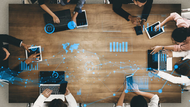 A vibrant and modern collaborative workspace showcasing diverse professionals engaged in data analysis using laptops and tablets, enhanced with futuristic graphics. Xenic
