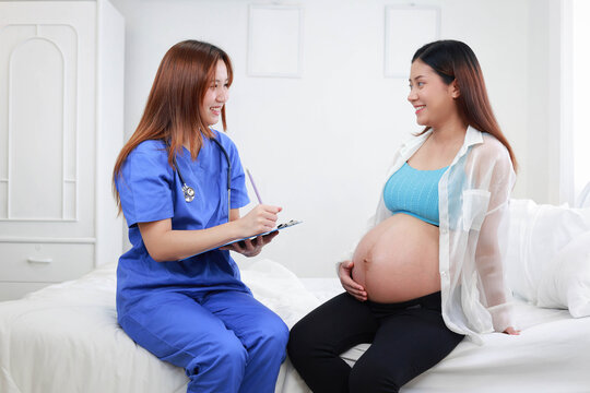Doctor holding a clipboard and consulting a pregnant woman during a routine prenatal checkup, highlighting healthcare, maternity support, and monitoring fetal development.