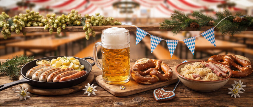 A rustic autumn feast featuring a cold glass of foamy beer, a cast-iron skillet with sausages and potatoes, traditional pretzels, and a bowl of sauerkraut on a wooden table.